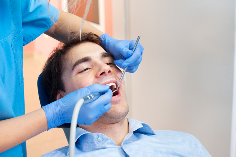 Man receiving dental cleaning from dental hygienist at Uptown Family Dental in Portland, OR