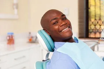 man smiling in the dental chair at Uptown Family Dental